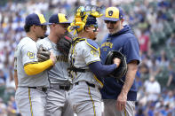 Milwaukee Brewers pitching coach Chris Hook, right, talks to catcher William Contreras as Willy Adames, left, and Tobias Myers listen during the first inning of a baseball game against the Chicago Cubs Saturday, May 4, 2024, in Chicago. (AP Photo/Charles Rex Arbogast)