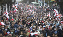 People with old Belarusian national flags march during an opposition rally to protest the official presidential election results in Minsk, Belarus, Sunday, Sept. 27, 2020.Hundreds of thousands of Belarusians have been protesting daily since the Aug. 9 presidential election. (AP Photo/TUT.by)