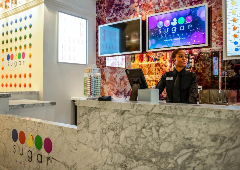 Micah West, 24, stands behind the counter inside the Sugar Factory American Brasserie in Detroit on Tuesday, Sept. 6, 2022.