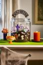 <p>Fill a large glass cookie jar with crumbs from your favorite chocolate cake along with white chocolate bones. Layer in tombstone sugar cookies decorated with gray, black, and purple royal icing. Pipe in tufts of grass using green-tinted buttercream. Push in a cemetery sign made from card stock and painted wood skewers.</p>