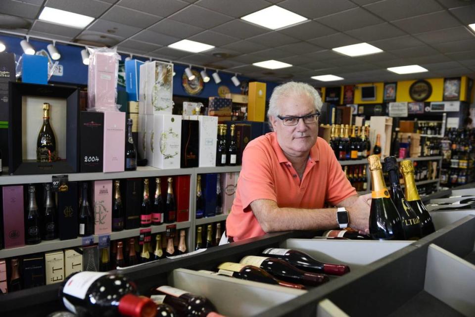 In this file photo from Dec. 28, 2015, Sunset Corners Wines and Liquors owner Michael Bittel holds Syltbar prosecco, a sparkling wine. Holiday season 2023 special deals at Sunset Corners, which was established in the South Miami area at 8701 SW 72nd St. in 1954, include Nicolas Feuillatte Brut Champagne from France is on sale for $29.99. Daou Reserve Cabernet 2021 from Paso Robles, California is on sale for $44.99 andBanfi Centine Rosso from Tuscany, Italy is $14.99.