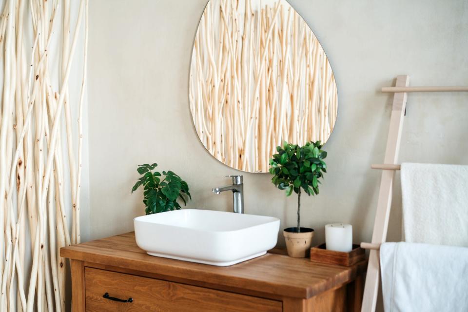 Funky-shaped mirror above sink in bathroom