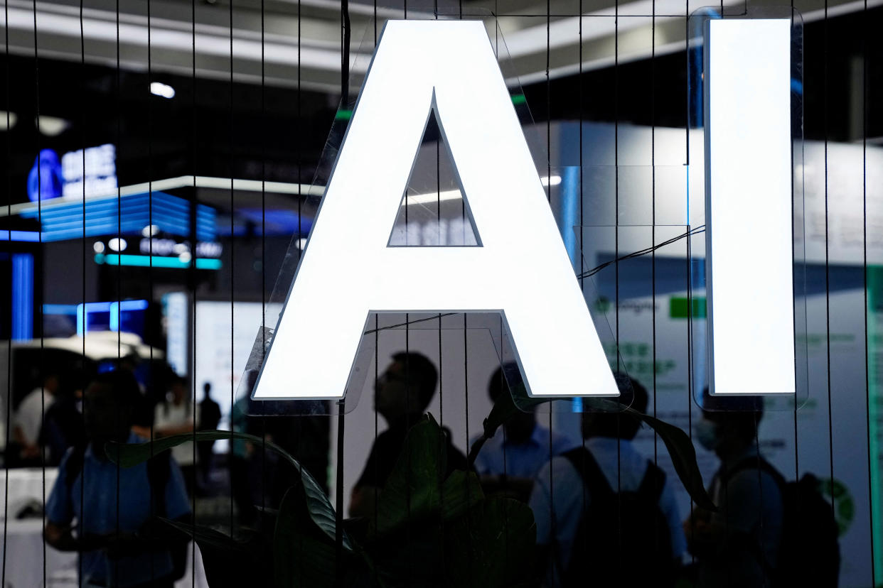 A large lit-up AI sign is shown with people underneath.