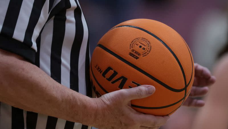 A referee holds the ball during a high school basketball game on Tuesday, Dec. 12, 2023.