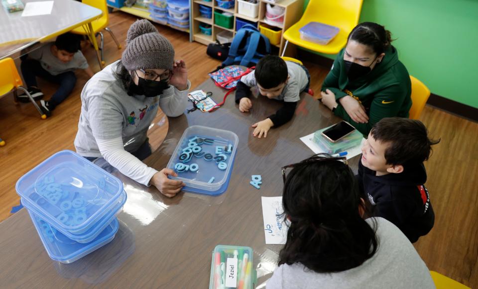 Norma Zapien, La Escuelita program coordinator, works with children on their letters during a session on Feb. 1.
