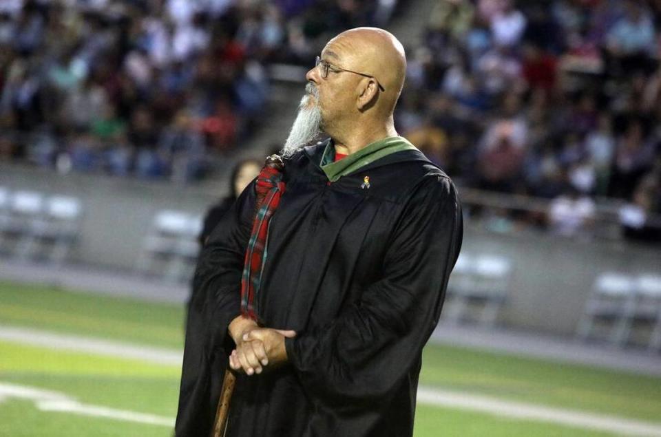 Track coach and teacher Jeff Woods waits for the graduates during the McLane High graduation at the school stadium on June 6, 2023.