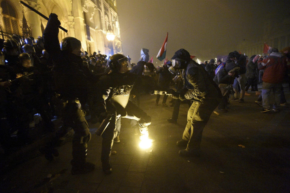 Protesters clash with police during a demonstration against the amendments to the labour code, dubbed "slave law" by oppositional forces, at the parliament building in Budapest, Hungary, Dec. 13, 2018. The rally, which was announced by the Free University and Students Trade Union student groups, started peacefully but police later responded to aggressive protestors with teargas. (Zoltan Balogh/MTI via AP)