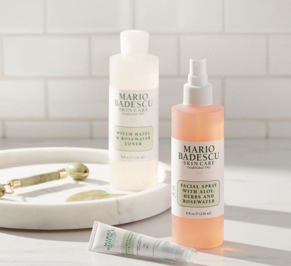 A bottle of facial spray, toner, eye serum, and a jade roller