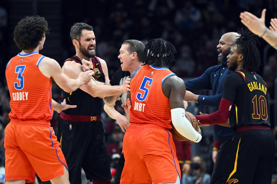 Referee Ed Malloy tries to separate Cleveland's Kevin Love and OKC's Luguentz Dort (5) after the two began to argue after battling for a loose ball during the fourth quarter on Saturday.