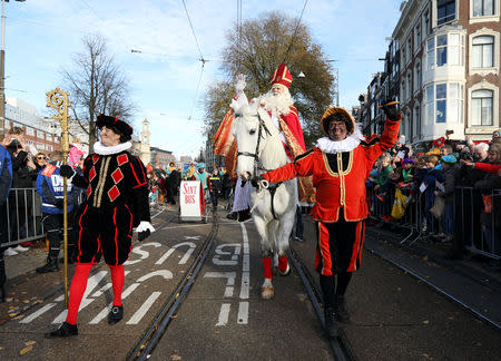 Saint Nicholas is escorted by his assistants called "Zwarte Piet" (Black Pete) during a traditional parade in Amsterdam, Netherlands, November 18, 2018. REUTERS/Eva Plevier