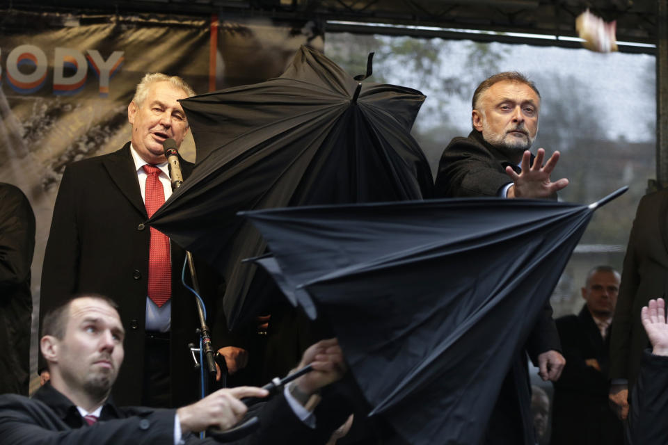 FILE - In this Monday, Nov. 17, 2014 file photo, security personnel use umbrellas to cover Czech Republic's President Milos Zeman, top left, during his speech commemorating the 1989 anti-communist Velvet Revolution in Prague, Czech Republic. Wednesday, March 8, 2023 marks the final day in office of outgoing Czech President Milos Zeman, with his opponents planning to celebrate. Zeman has polarized the Czechs during his two five-year terms in the normally largely ceremonial post with his support for closer ties with China and by being a leading pro-Russian voice in European Union politics. (AP Photo/Petr David Josek/File)