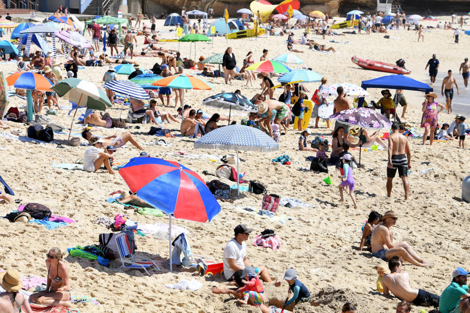 Lots of people seen sitting on beach.