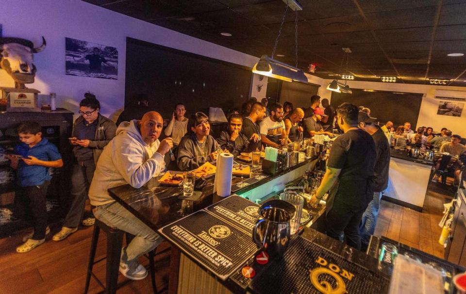 Escena de clientes comiendo en la barra del popular restaurante Apocalypse BBQ en Kendall.