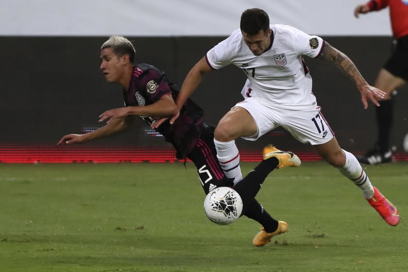 Mexico's Uriel Antuna, left, and United States' Aaron Herrera fight for the ball during a Concacaf Men's Olympic Qualifying championship soccer match in Guadalajara, Mexico, Wednesday, March 24, 2021. (AP Photo/Fernando Llano)