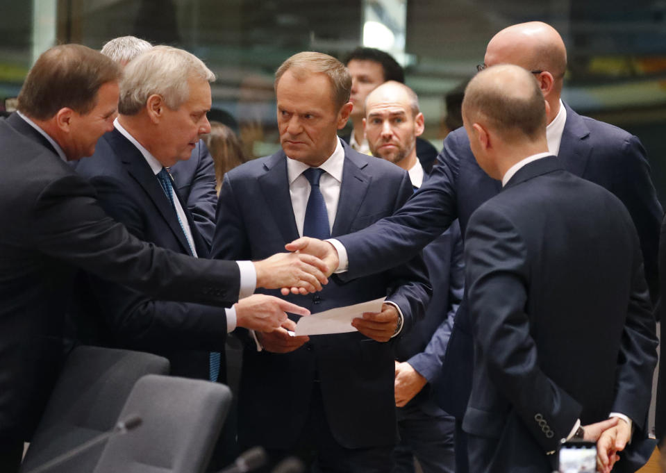 European Council President Donald Tusk, center, speaks with Finnish Prime Minister Antti Rinne, second left, and Belgian Prime Minister Charles Michel, second right, during a round table meeting at EU summit in Brussels, Friday, Oct. 18, 2019. After agreeing on terms for a new Brexit deal, European Union leaders are meeting again to discuss other thorny issues including the bloc's budget and climate change. (AP Photo/Frank Augstein)