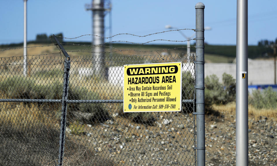 In this Wednesday, Aug. 14, 2019 photo, a sign at the Hanford Nuclear Reservation warns of possible hazards in the soil there along the Columbia River near Richland, Wash. Washington state officials are worried that the Trump administration wants to reclassify millions of gallons of wastewater at Hanford from high-level radioactive to low-level, which could reduce cleanup standards and cut costs. (AP Photo/Elaine Thompson)