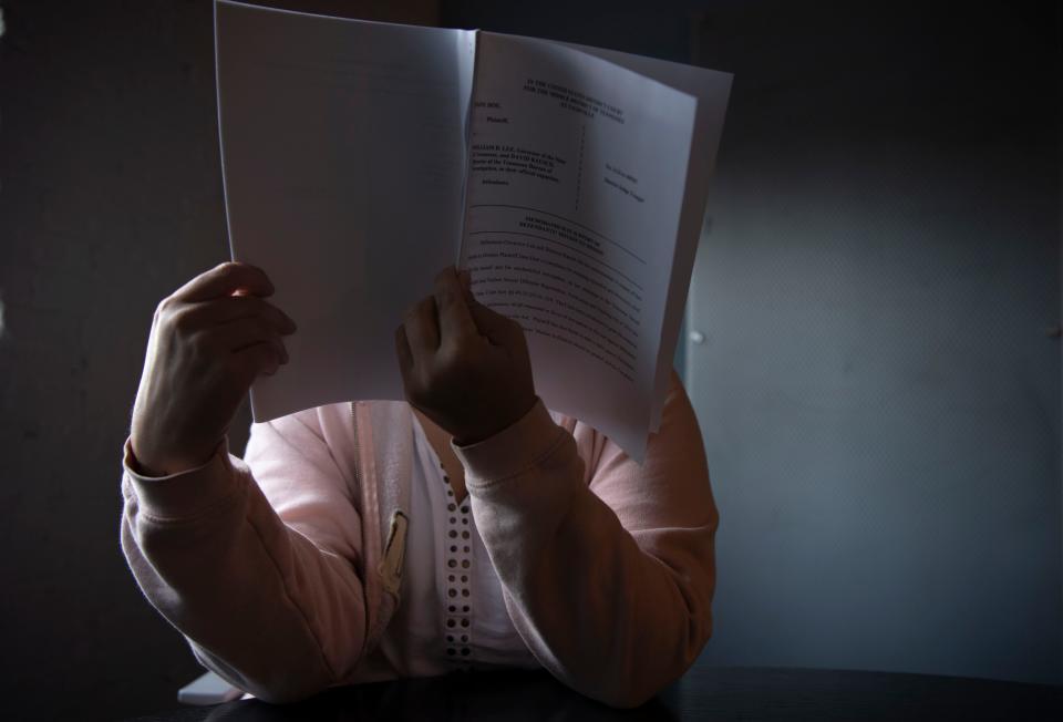 A woman reads her lawsuit filed in federal court challenging portions of Tennessee's sexual offender registry statutes at her attorney's office in Nashville, Tenn., on Wednesday, Oct. 18, 2023.