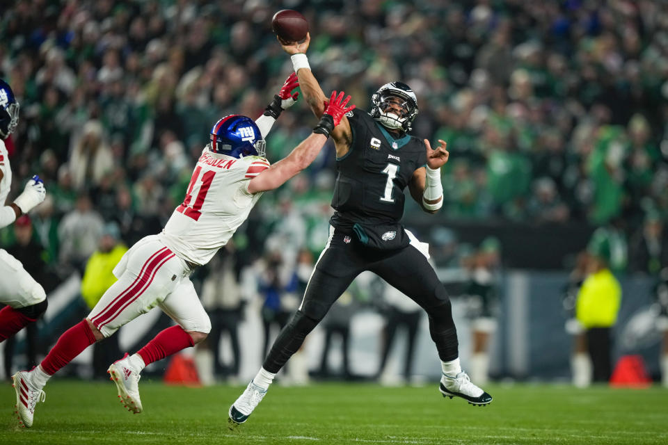 Philadelphia Eagles quarterback Jalen Hurts passes under pressure by New York Giants linebacker Micah McFadden during the first half of an NFL football game Monday, Dec. 25, 2023, in Philadelphia. (AP Photo/Matt Slocum)