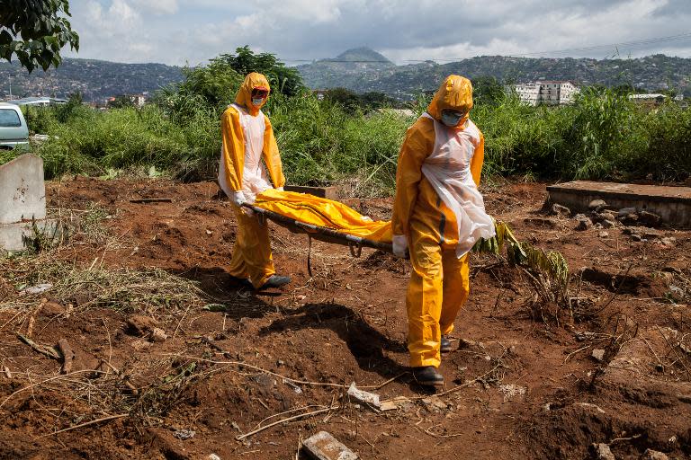 A team of funeral agents specialised in the burial of victims of the Ebola virus carry a body at the Fing Tom cemetery in Freetown, on October 10, 2014