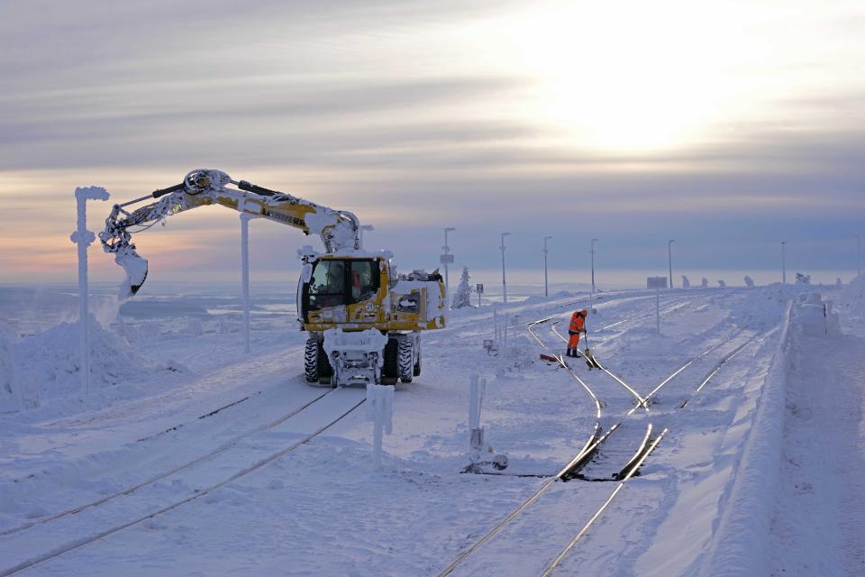 Railroad worker clear the tracks of snow on northern Germany's 1,142-meter (3,743 feet) highest mountain 'Brocken' at the Harz mountains near Schierke, Germany, Wednesday, Jan. 17, 2024. (AP Photo/Matthias Schrader)