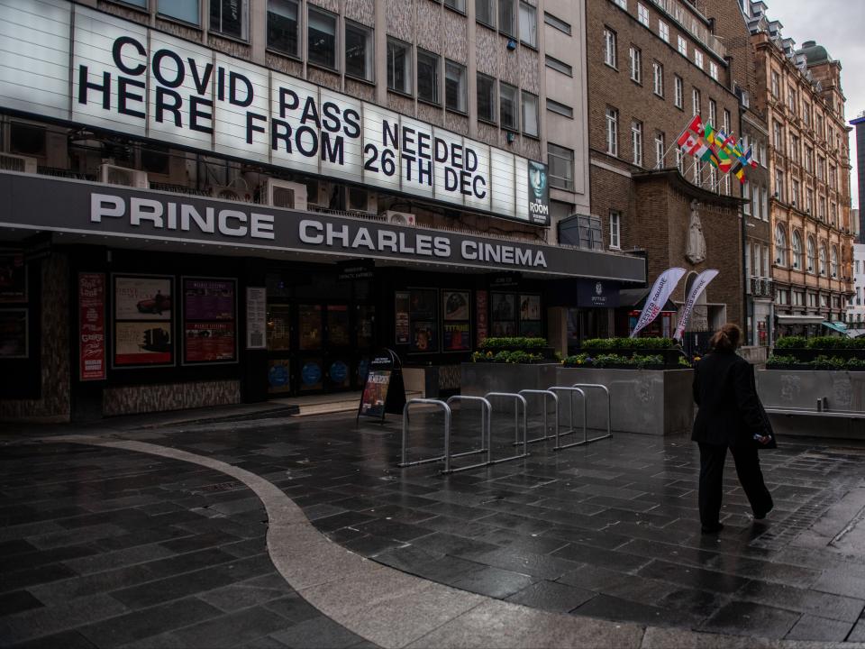 A deserted-looking cinema near Leicester Square advertises the need for a Covid pass to enter (Getty)