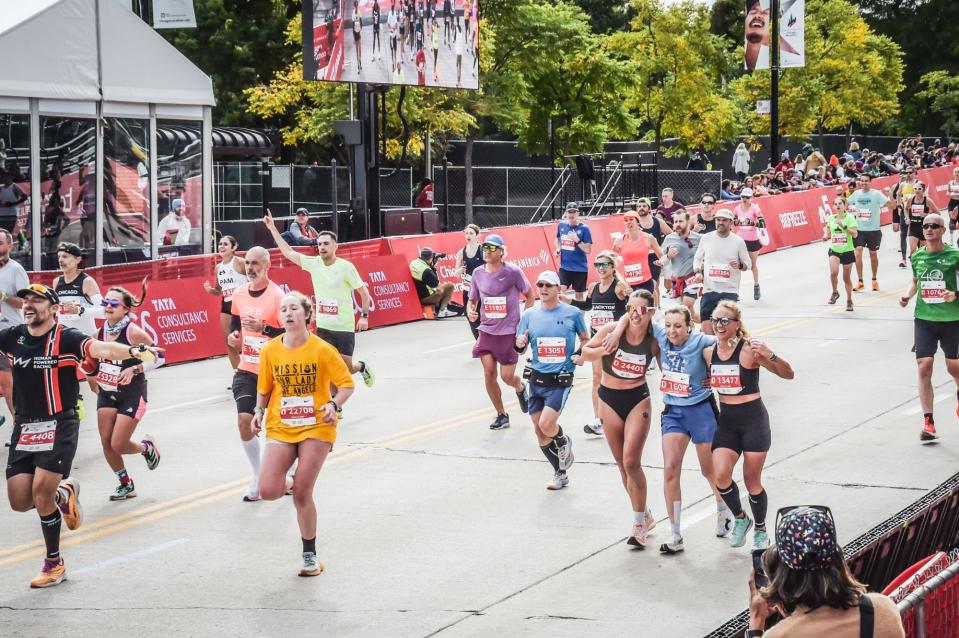 Sarah Bohan (left) and Gia Nigro (right) help an injured runner across the finish line.