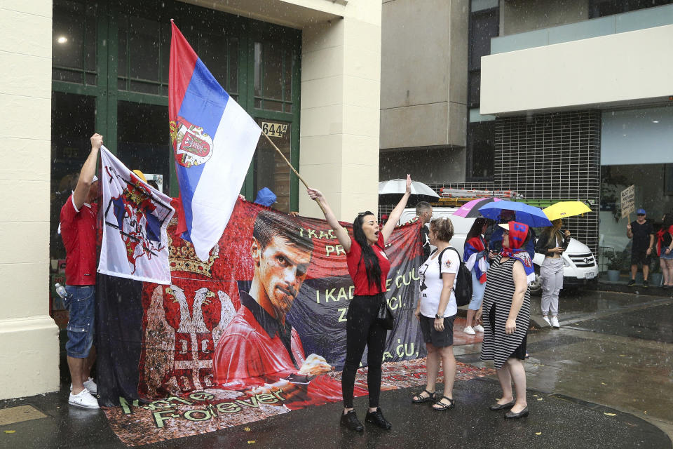 Protestors gather outside an immigration detention hotel where Serbia's Novak Djokovic is believed to stay, in Melbourne, Australia, Friday, Jan. 7, 2022. Locked in a dispute over his COVID-19 vaccination status, Djokovic was confined to the immigration detention hotel in Australia on Thursday as the No. 1 men's tennis player in the world awaited a court ruling on whether he can compete in the Australian Open later this month. (AP Photo/Hamish Blair)