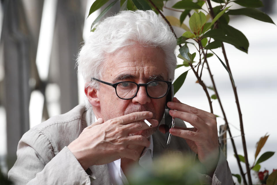 Michel Platini's lawyer William Bourdon makes a call outside the Anti-Corruption Office of the Judicial Police headquarters in Nanterre, outside Paris,Tuesday, June 18, 2019. Former UEFA president Michel Platini proclaimed his innocence during police questioning Tuesday following his arrest as part of a corruption probe into the vote that gave the 2022 World Cup to Qatar. (AP Photo/Christophe Ena)