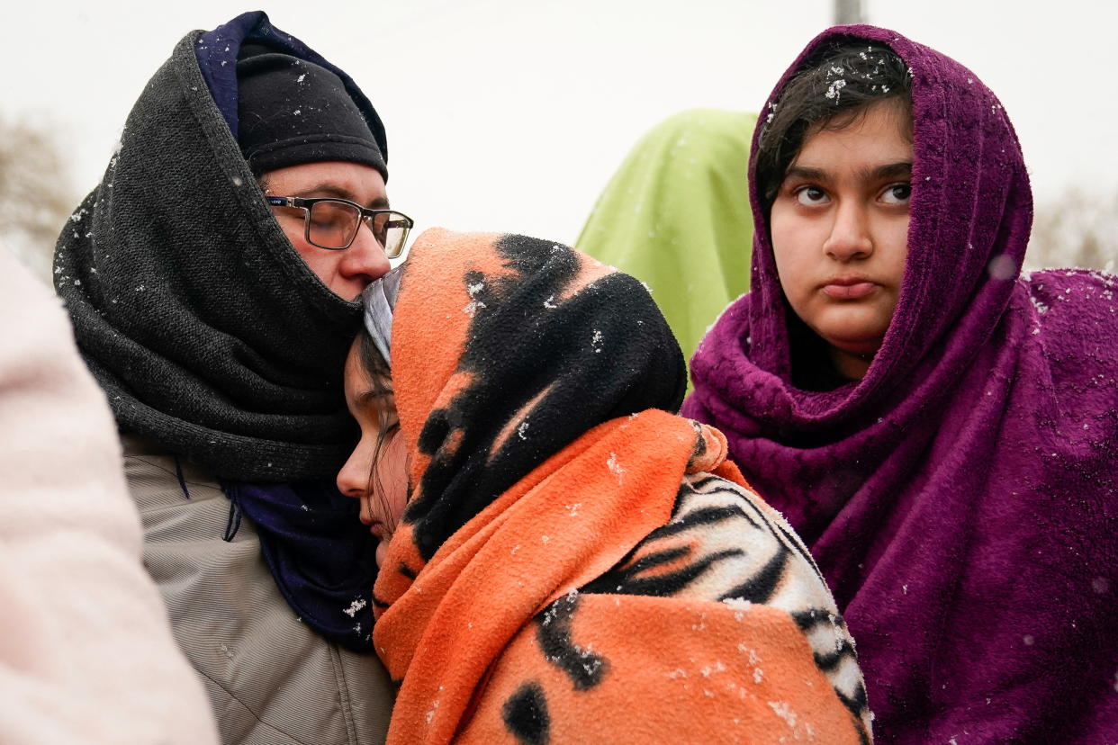 An Afghan family, who once fled the war in Afghanistan, wait to board a bus bound for a refugee centre, after fleeing the Russian invasion in Ukraine, in Medyka, Poland, February 28, 2022. REUTERS/Bryan Woolston