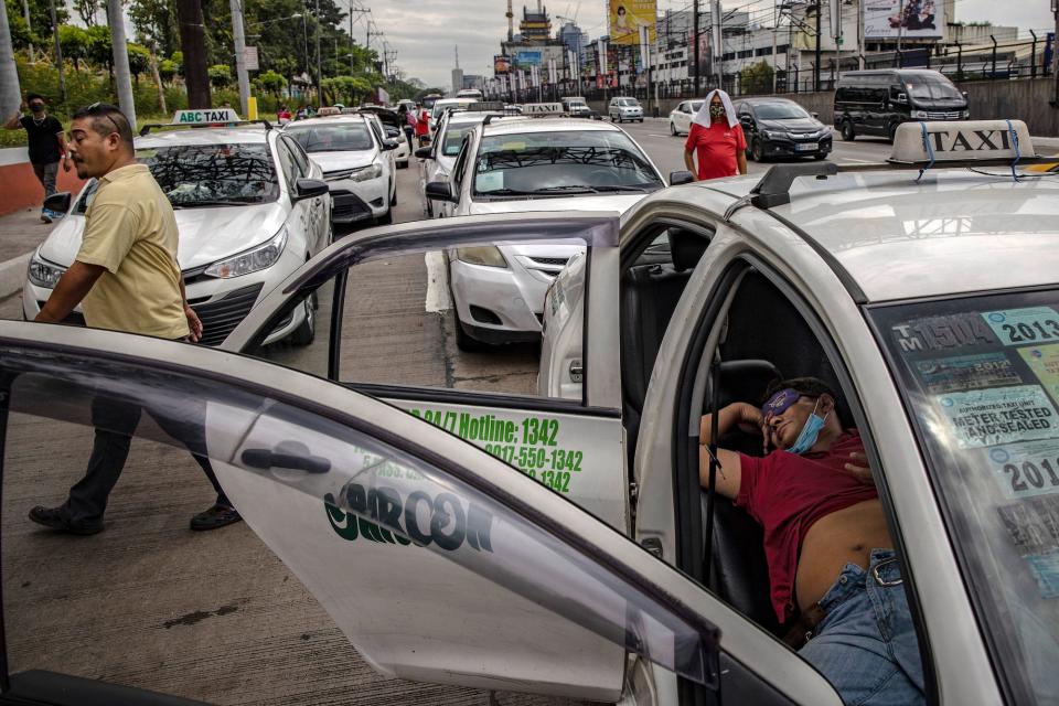 Apprehended taxis are parked along a major highway after authorities cracked down on public transportation as part of measures to prevent the spread of COVID-19 on March 17, 2020 in Quezon city, Metro Manila, Philippines.