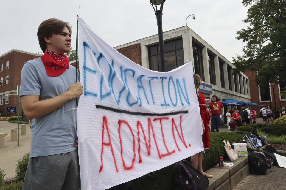 West Virginia University students hold a banner during a protest outside the Mountainlair student center against proposed cuts to programs in world languages, creative writing and more amid a $45 million budget deficit Morgantown, W.Va., on Monday, Aug. 21, 2023. (AP Photo/Leah Willingham)