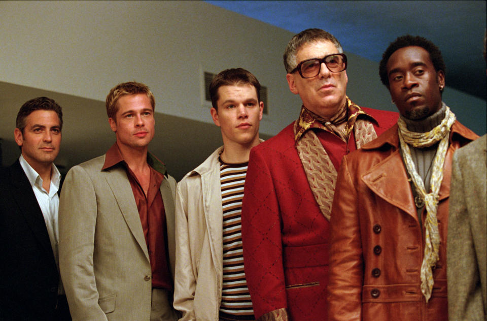 George Clooney, Brad Pitt, Matt Damon, Elliott Gould, and Don Cheadle in semi-formal outfits in a scene from "Ocean's Eleven"