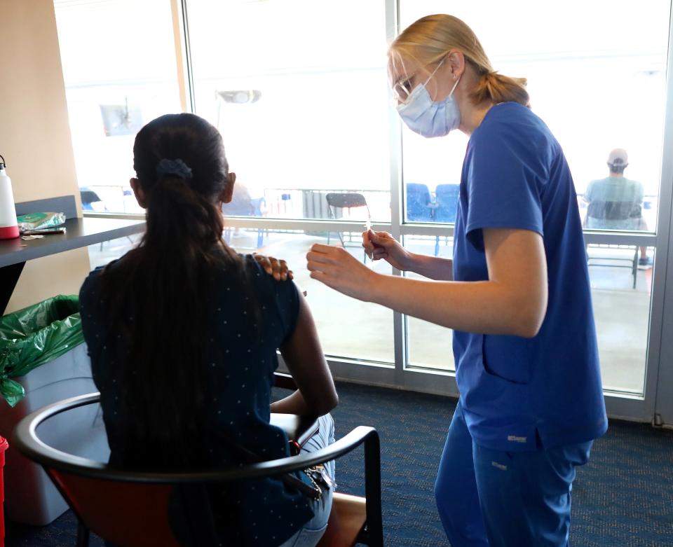 A medical assistant at the UF Health Student Health Care-Center prepare to give a dose of the Pfizer COVID-19 vaccine at a mass vaccine site located in the Champion Clubs at Ben Hill Griffin Stadium in Gainesville on May 7.
