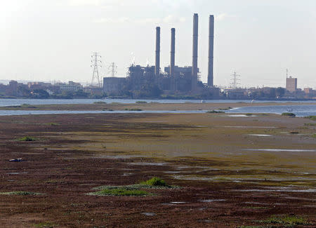 A boat is seen stranded in the mud at low tide on the River Nile in front of a South Cairo Electricity Distribution Company power station in Cairo, Egypt, November 23, 2017. Picture taken November 23, 2017. REUTERS/Amr Abdallah Dalsh