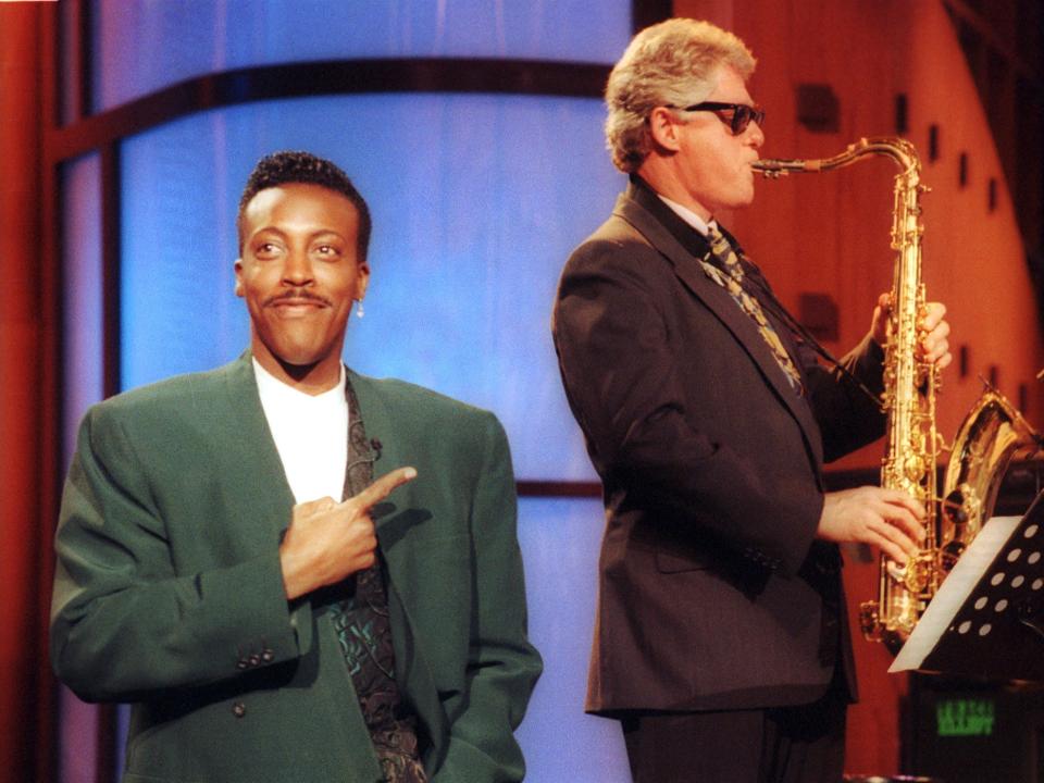 1992 Democratic presidential candidate Bill Clinton plays the saxophone as TV host Arsenio Hall stands by and points during a taping of a late night show.