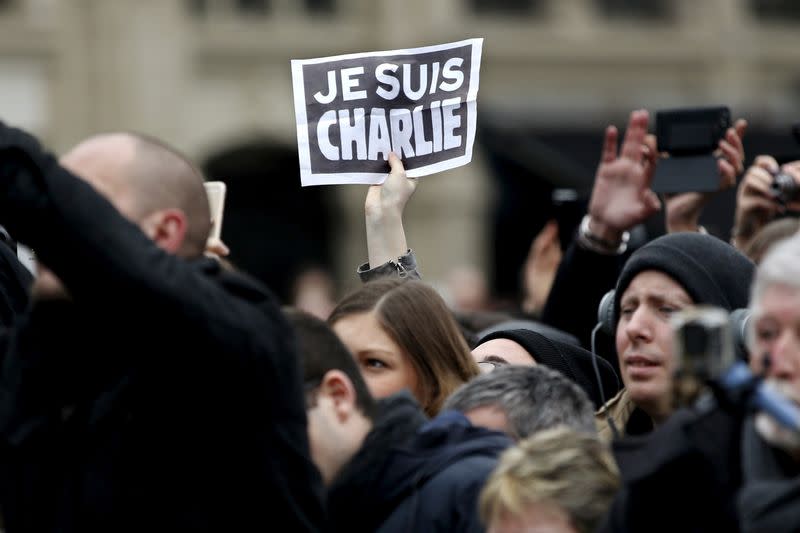 FILE PHOTO: Person holds up a sign during a ceremony at Place de la Republique square to pay tribute to the victims of last year's shooting at the French satirical newspaper Charlie Hebdo, in Paris