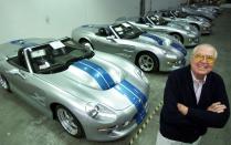 Automotive legend Carroll Shelby poses in front of his Shelby Series 1 sports cars at his plant in Las Vegas, Friday, Oct. 27, 2000. The Texas-born Shelby is mass producing a new generation of roadsters not in Detroit, but in the desert outside Las Vegas. The $174,975 Shelby Series 1 sports cars are 21st-century clones of his 1965 Cobra. And unlike his earlier model, the Shelby Series 1 has creature comforts like roll-up windows and air conditioning. (AP Photo/K.M. Cannon)