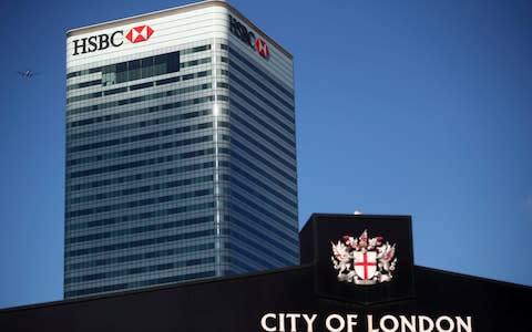 HSBC's building in Canary Wharf is seen behind a City of London sign outside Billingsgate Market in London - Credit: &nbsp;Hannah Mckay/REUTERS