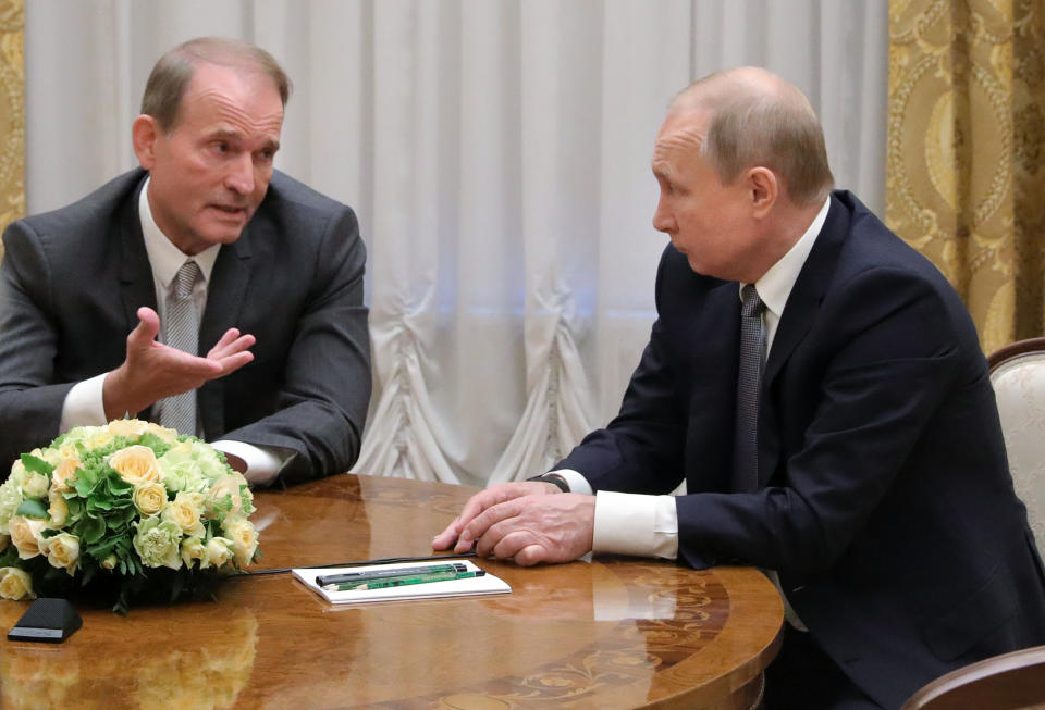 FILE - In this Thursday, July 18, 2019 file photo, Russian President Vladimir Putin's close associates, Ukrainian tycoon Viktor Medvedchuk, left, speaks to Russian President Vladimir Putin during their meeting in St. Petersburg, Russia. Medvedchuk, who heads the Opposition Platform for Life party and has close ties with Putin, was placed under house arrest on Thursday, May 13, 2021 by a Ukrainian court on treason charges that he denied. (Mikhail Klimentyev, Sputnik, Kremlin Pool Photo via AP, File)