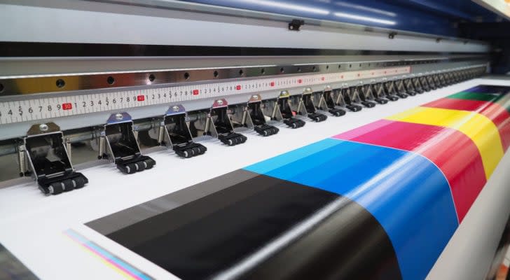 A test page with various bright colors is shown printing from a wide format inkjet printer.