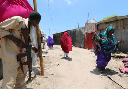 A Somali soldier holds position as civilians evacuate from the scene of a suicide explosion after al-Shabaab militia stormed a government building in Mogadishu, Somalia March 23, 2019. REUTERS/Feisal Omar