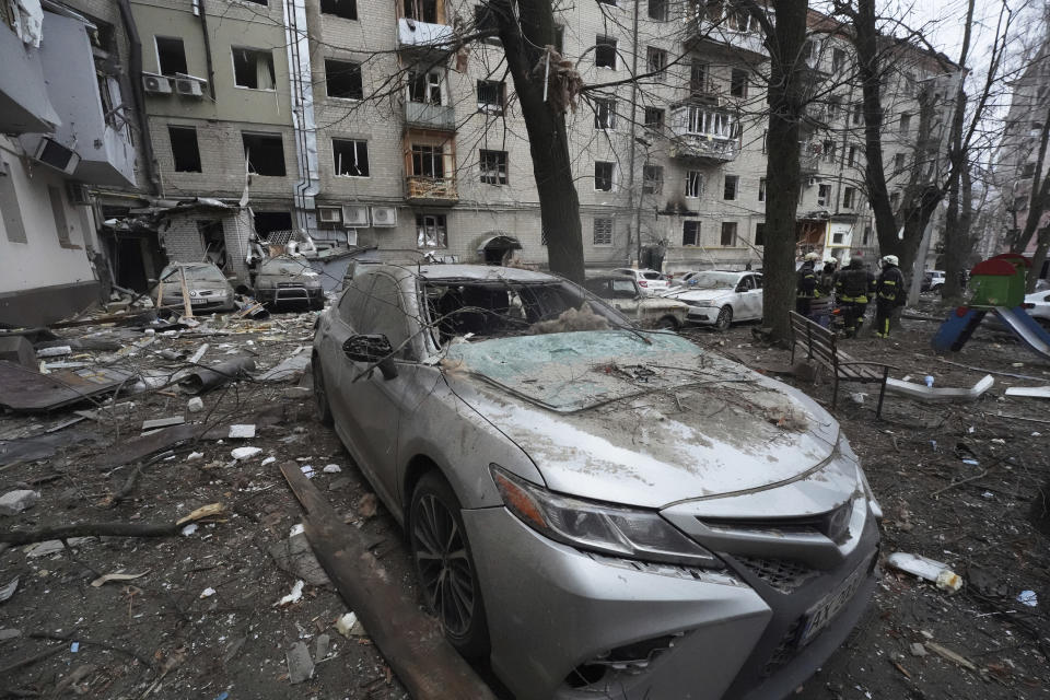 A damaged car is parked in the yard of a residential building damaged by a Russian missile strike in Kharkiv, Ukraine, Tuesday, Jan. 2, 2024. (AP Photo/Andrii Marienko)