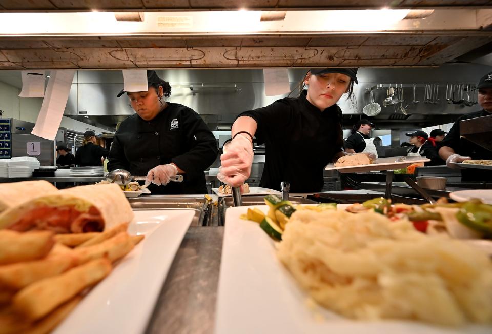 Bay Path Regional Vocational Technical High School culinary students and and juniors Luz Rodriguez-Cirino of Southbridge and Chloe Monahan of Charlton work on meals in the kitchen.