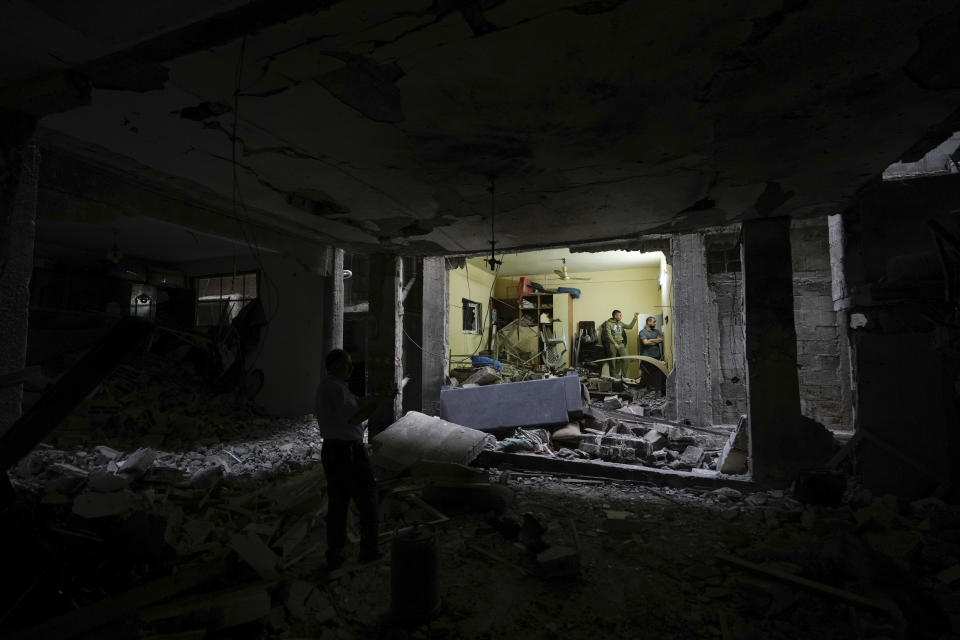 Palestinians inspect a damaged building following an Israeli army raid in the Balata refugee camp near the West Bank town of Nablus Monday, May 22, 2023. A Palestinian militant group said three members were killed in the raid. (AP Photo/Majdi Mohammed)
