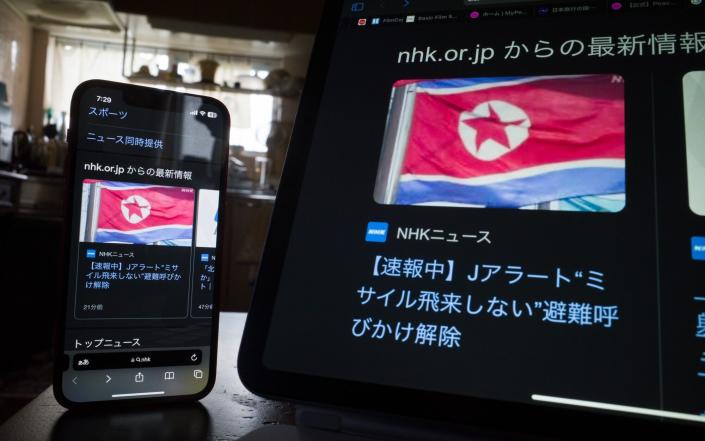 Screens display a missile alert warning for Okinawa prefecture - Bloomberg