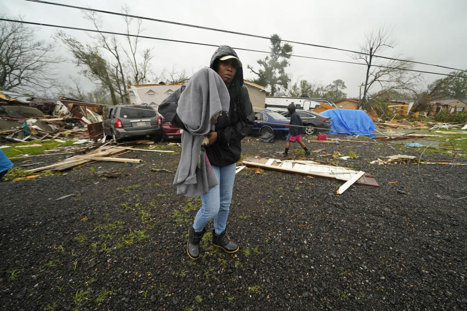 Chelsi Bovie holds her niece's dog that she rescued from her home after a tornado tore through the area in Killona, La., on Dec. 14, 2022.  (Gerald Herbert / AP)