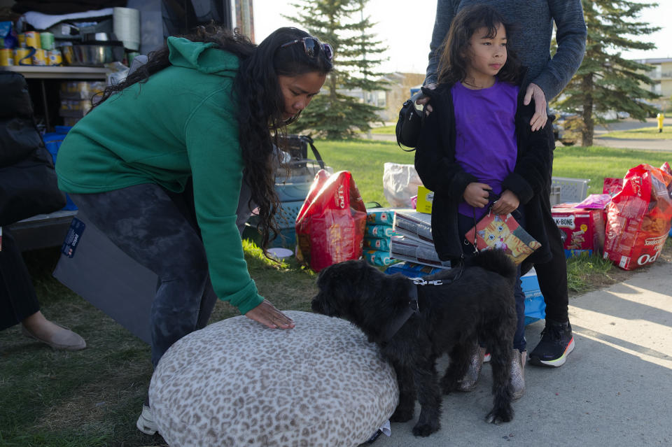 <p>Perlie LaRocque, a Fort Nelson, B.C. evacuee, tries to get her dog Cookie to try a new dog bed at the North Peace Arena in Fort St. John B.C., on Monday, May 13, 2024 as her daughter Frankie looks on. Wildfires are forcing more people to evacuate their homes in dry and windy northeastern B.C.</p> 
