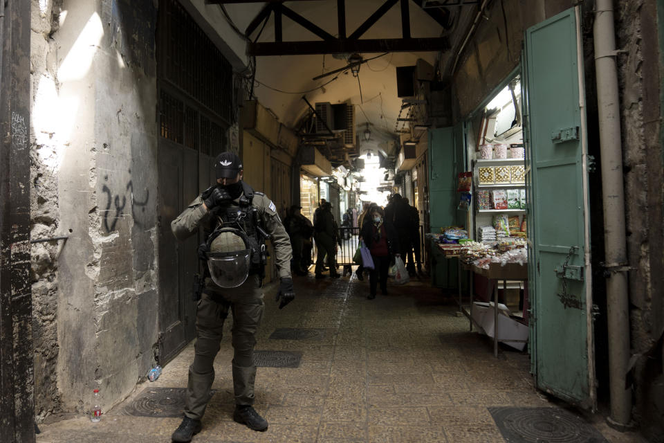 An Israeli Border Police officer stands guard as Christians walk in a procession along the Via Dolorosa, a route that is believed to be the path Jesus walked to his crucifixion, on Good Friday in the Old City of Jerusalem, Friday, April 7, 2023. (AP Photo/Maya Alleruzzo)