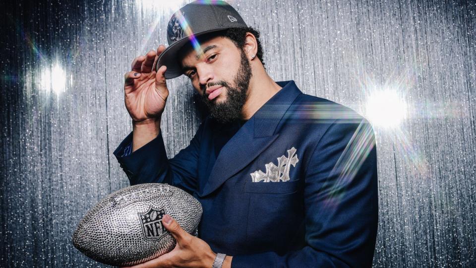 Chicago Bears quarterback Caleb Williams poses with an American football