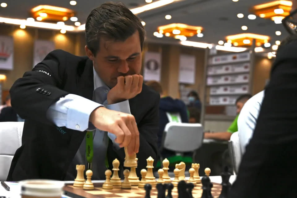 Pictured here is Magnus Carlsen playing against an opponent in a game of chess.